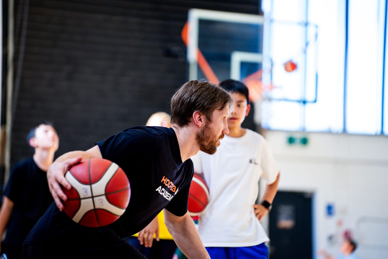 A Hoop33 Academy coach coaching young players with the ball