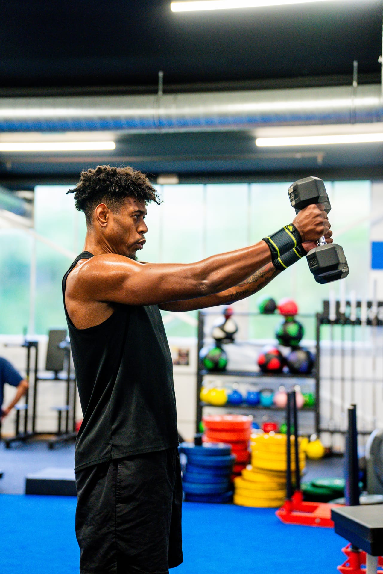 A member pressing dumbbells during a strength session