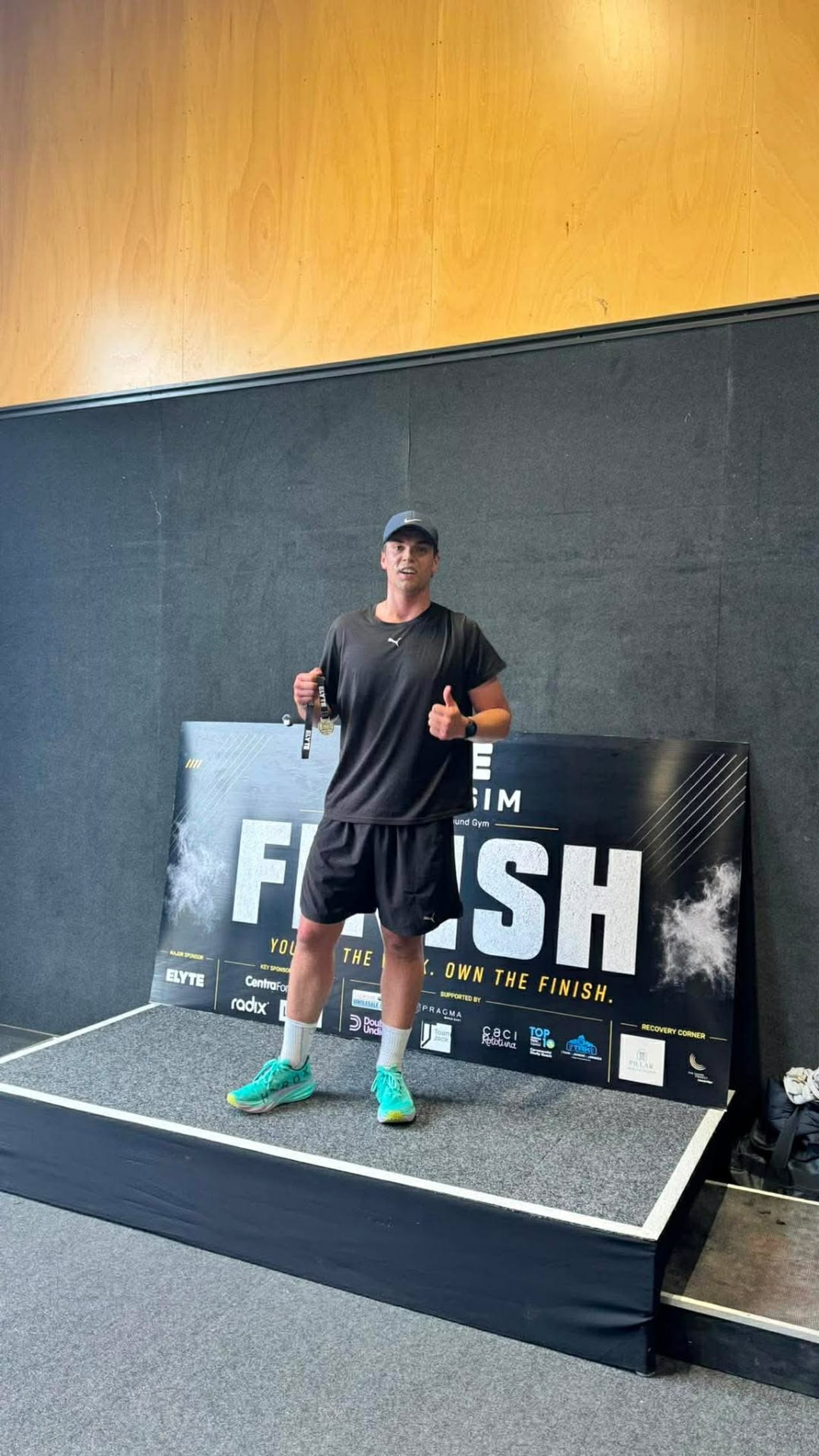Hoop33 member Josh Bilyard on the finish podium with his HYROX medal